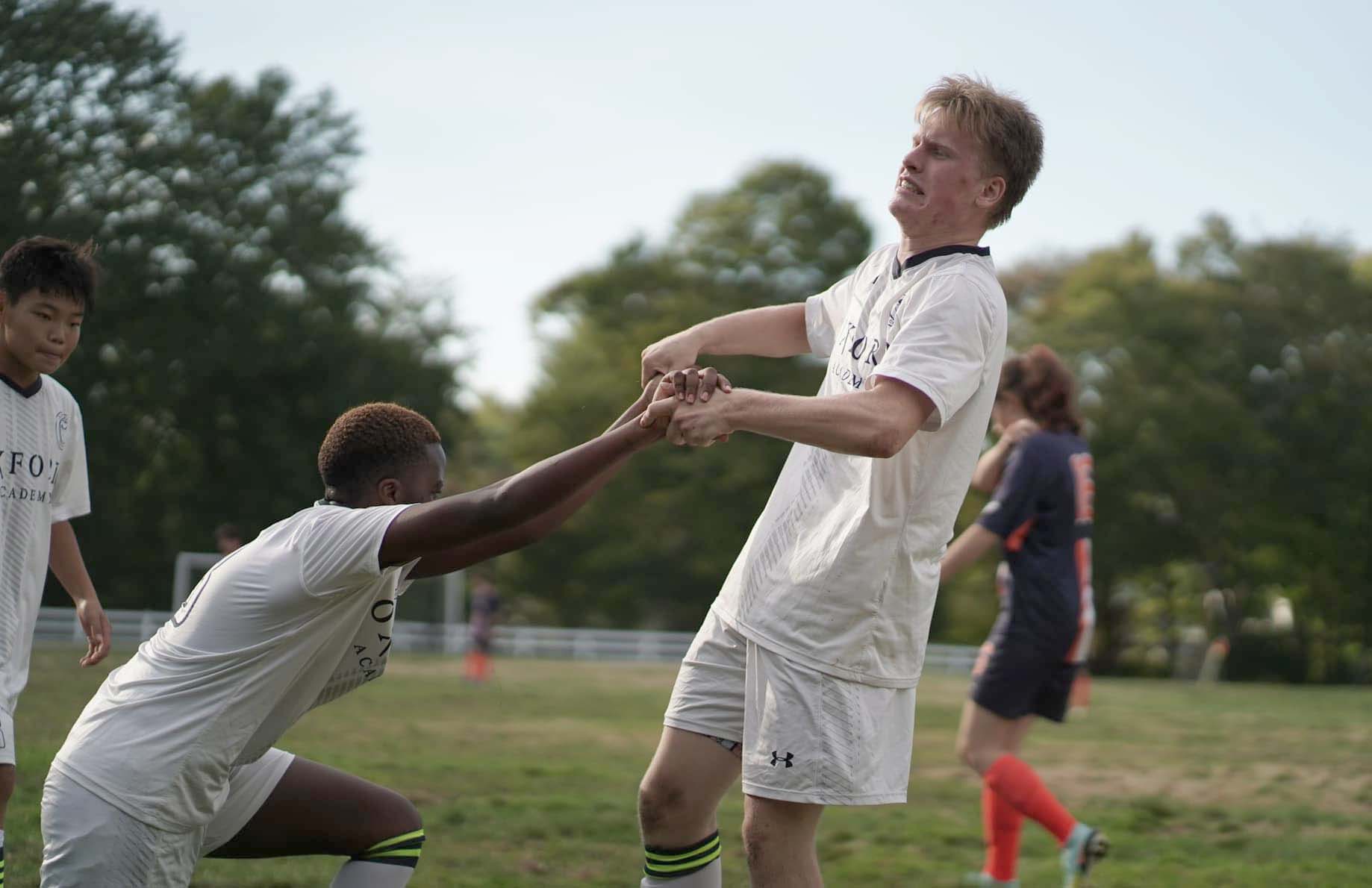 A group of young men playing soccer on a field at Oxford Academy - The Best Boarding School to Empower Teens with Learning Disabilities.