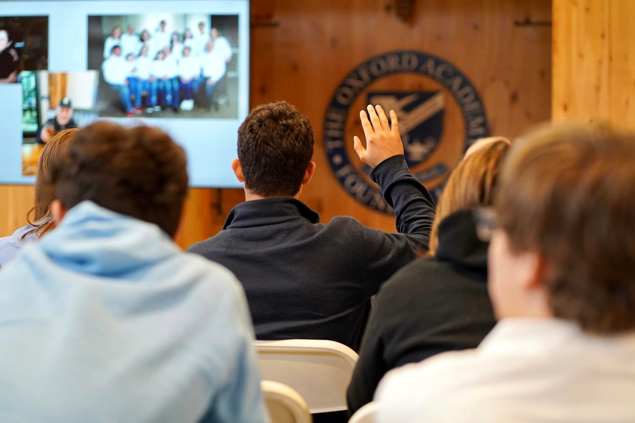 A group of people in front of a screen giving an empowering presentation on holistic education and executive function for teens.