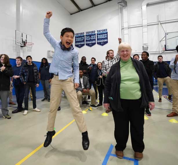 A man and a woman are jumping in a gymnasium.