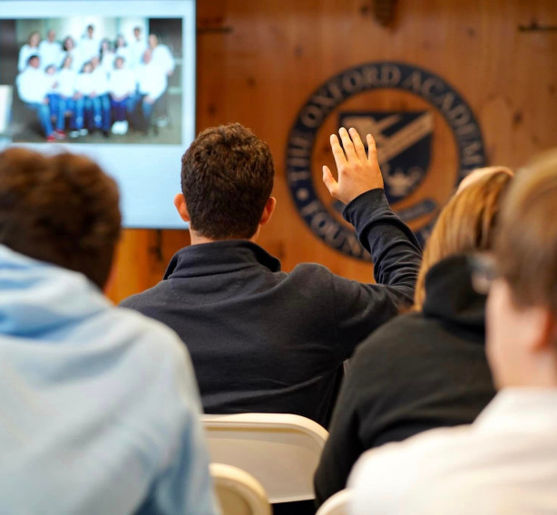 A group of people in front of a screen.