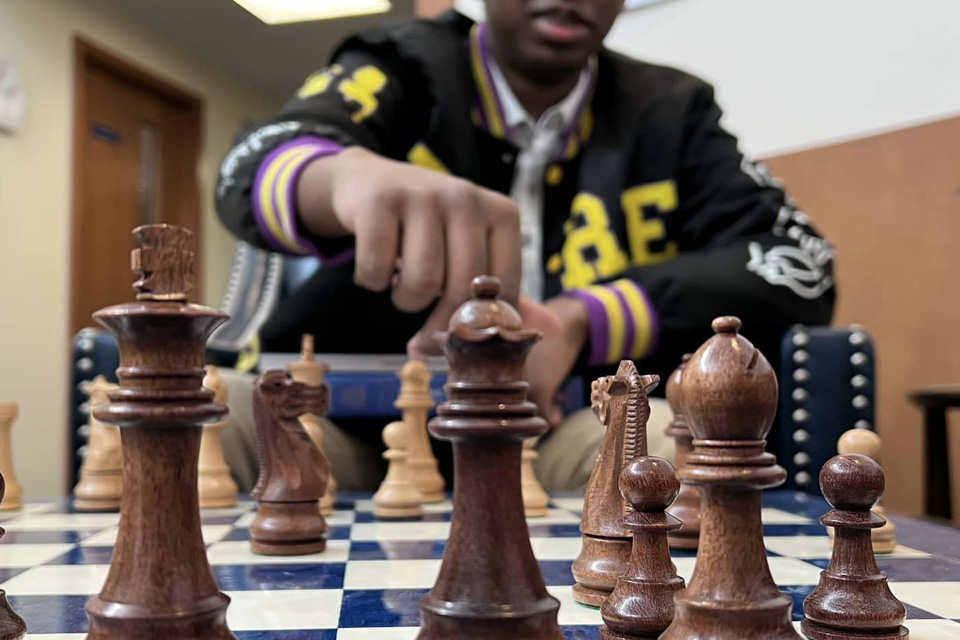 A person with ADHD playing chess, focusing on a move with a bishop.