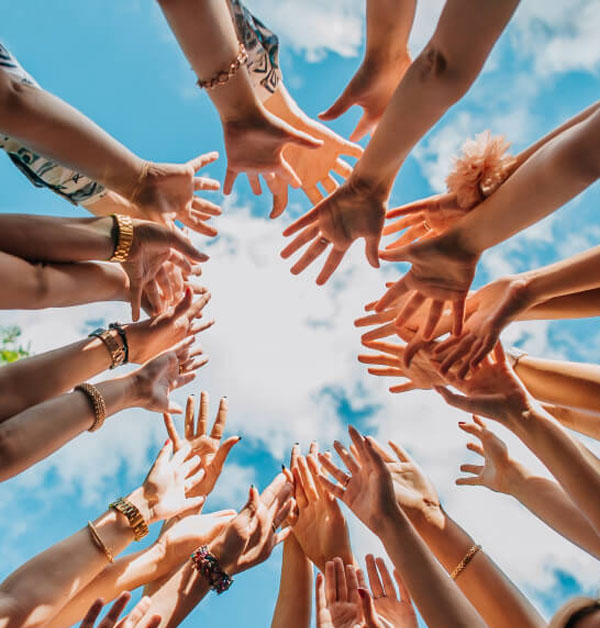 A group of people reaching their hands together in a circle.