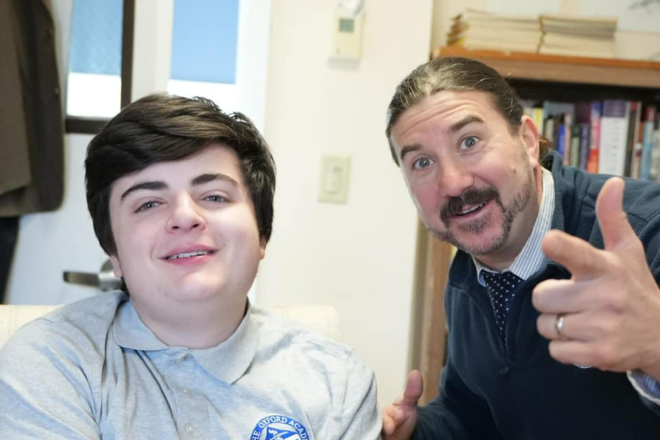 Two people pose in an office setting; the person on the right is gesturing and smiling enthusiastically, showcasing a Connecticut-based initiative focused on enhancing executive function for those with learning disabilities.